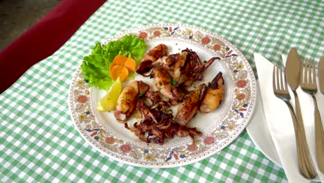 grilled and fried seafood on a traditional mediterranean plate garnished with summer vegetables and fruits - greece, croatia, italy, montenegro, squid.