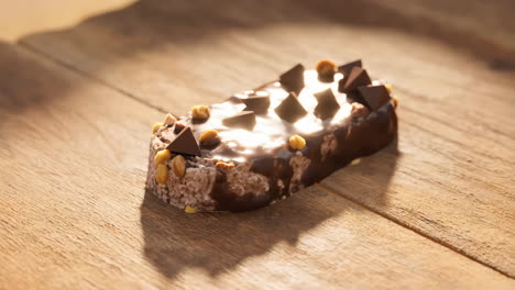delicious chocolate ice cream bar with nuts on a wooden table