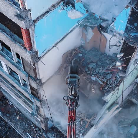 excavator grabber tears off the pieces of destroyed building. heavy machinery working at destruction site. view from above