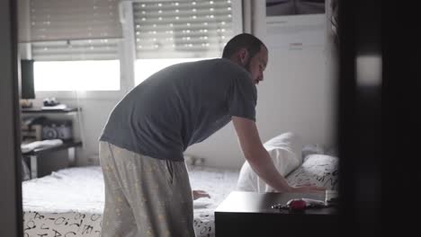 man making the bed in the morning before starting the day