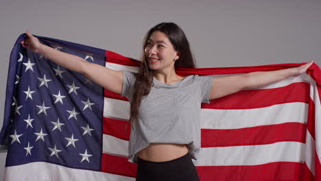 studio portrait shot of woman wrapped in american flag celebrating 4th july independence day 6