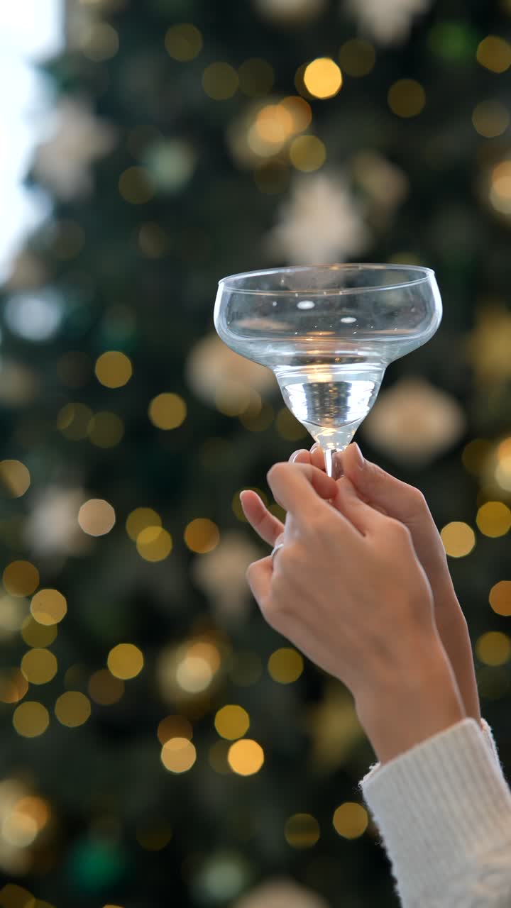 크리스마스 트리 앞에 테일 컵을 들고 있는 여자