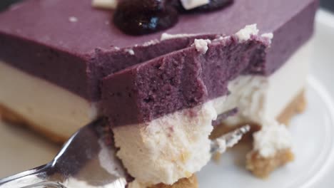 purple and white cheesecake with a bite