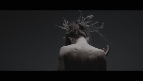 a woman dressed as mother nature moves slowly in a dance-like motion