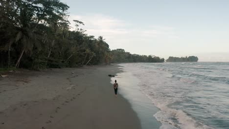 walking into the shore with splashing waves at punta mona paradise beach in costa rica