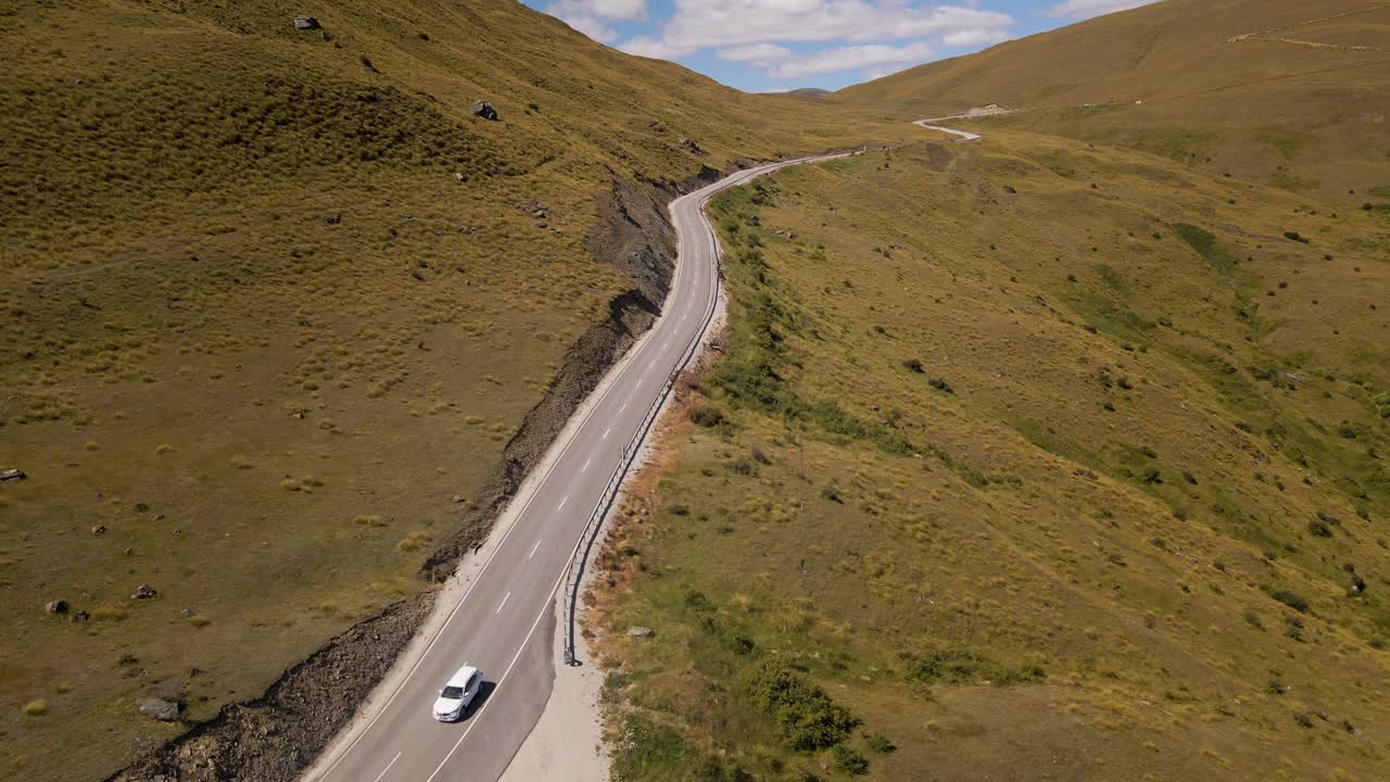 coche blanco en una pintoresca carretera alpina