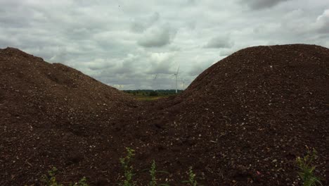 view of wind turbines through wasteland on cloudy grey day