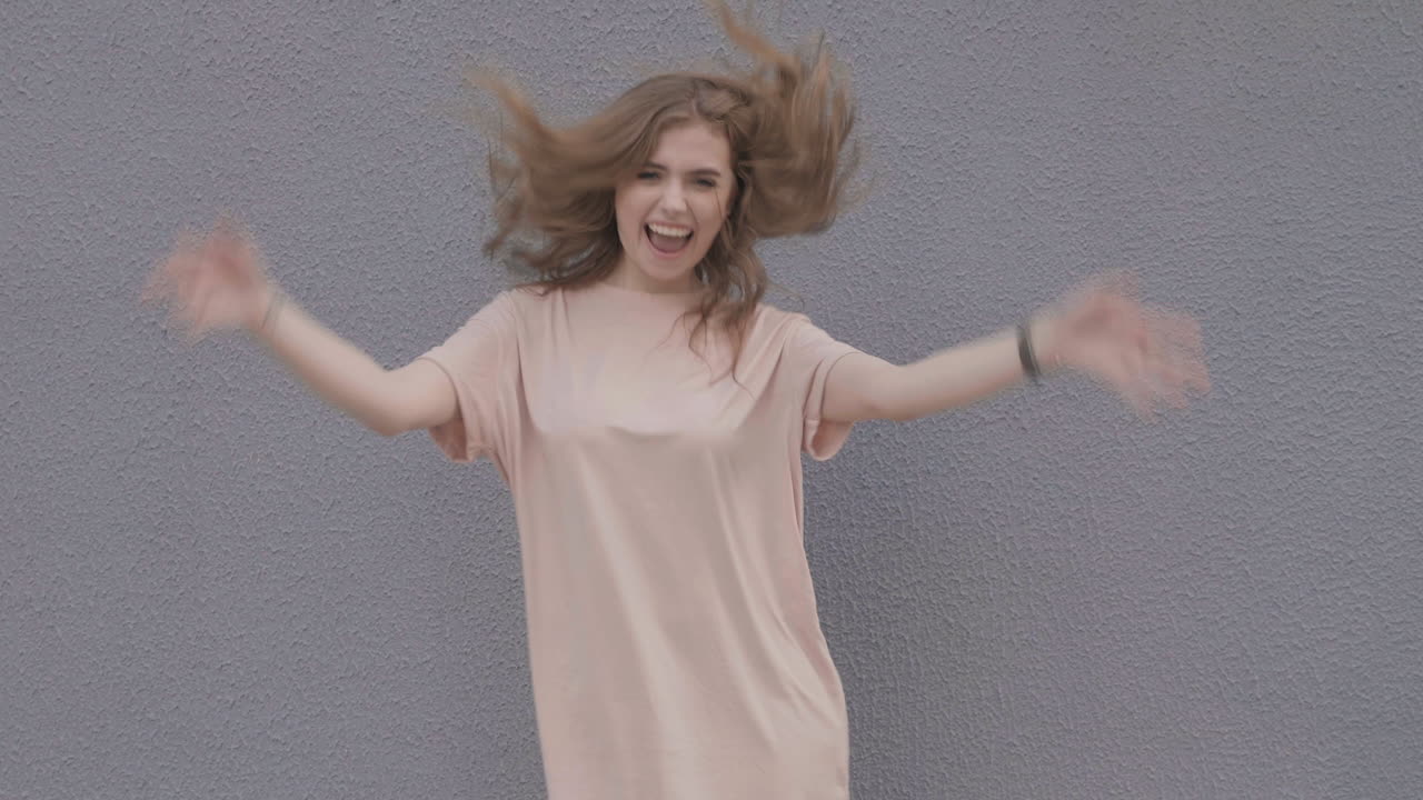 mujer posando contra una pared gris