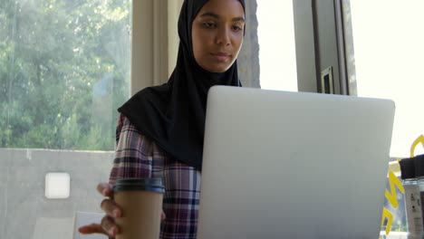 mulher jovem usando laptop em um café