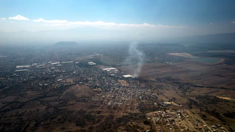 toma aérea de tierras de cultivo urbanas fuera de la ciudad de méxico durante un día muy contaminado
