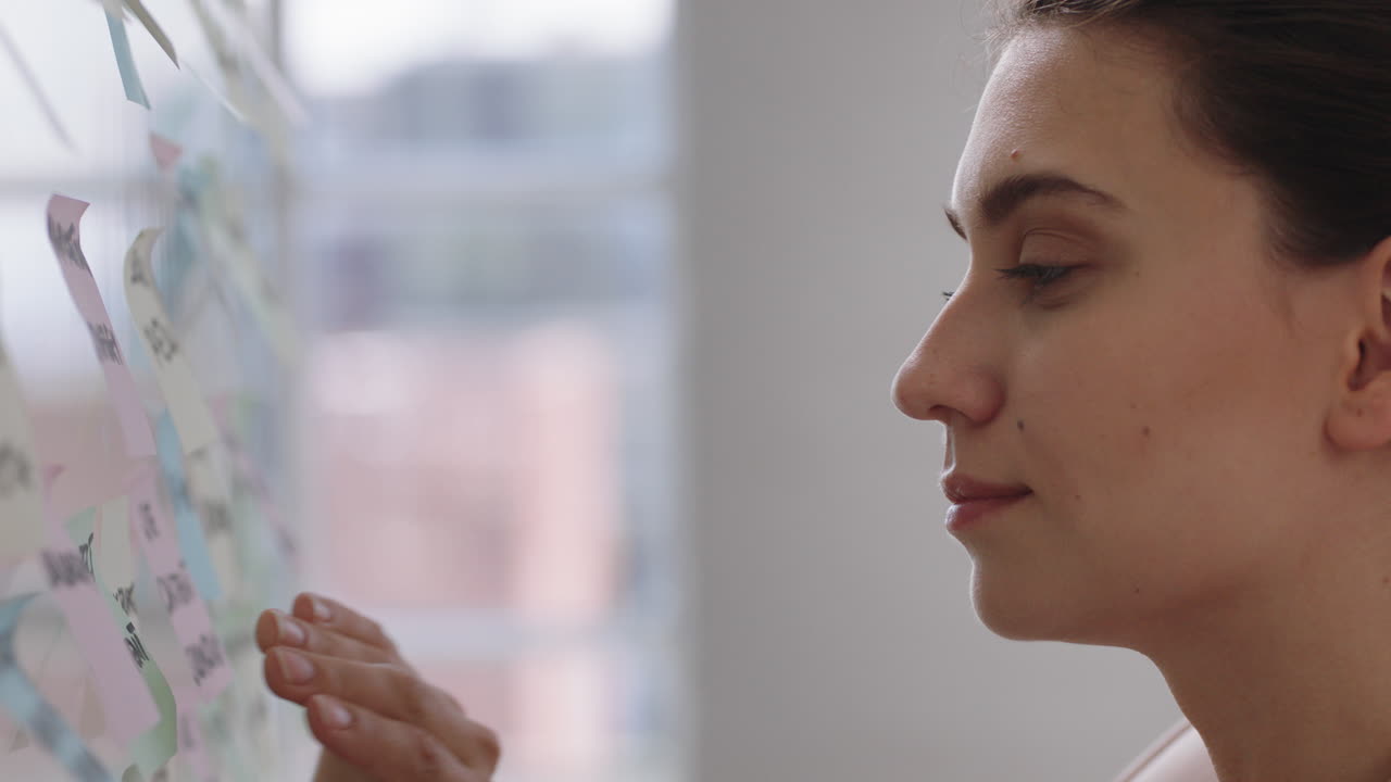 mujer de negocios que usa notas adhesivas, lluvia de ideas, resolución de problemas con creatividad, planificación de estrategias en la oficina, trabajo en la solución.