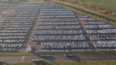 aerial landscape over vast parking lot with vehicles ready to be shipped,