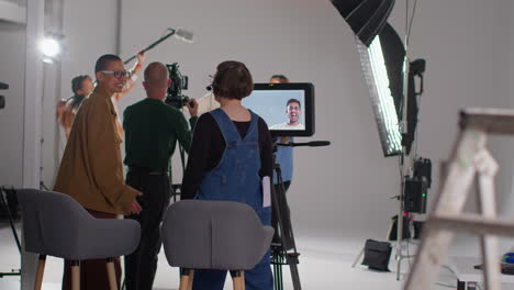 film crew and female director congratulating actors after performance shooting movie or video in studio 3