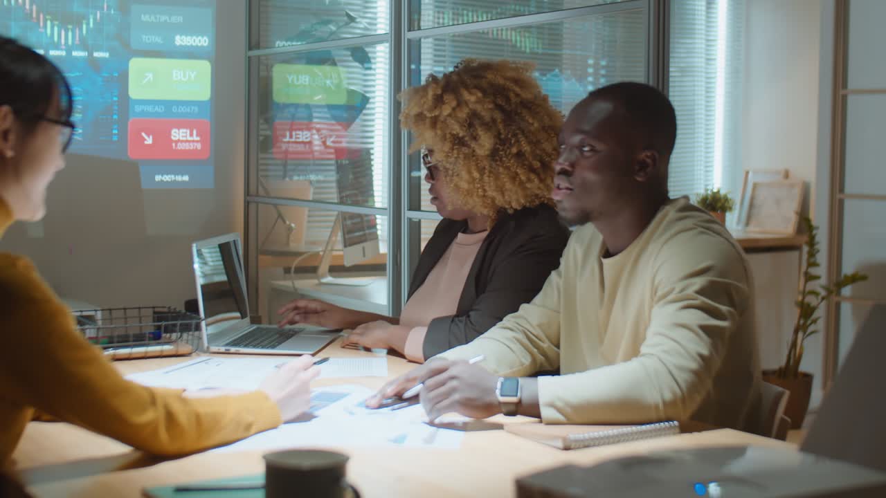 diversos colegas discutiendo un proyecto de negocio en una reunión nocturna de la oficina