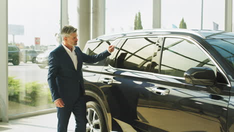 un hombre de negocios mirando un nuevo suv en un concesionario de automóviles