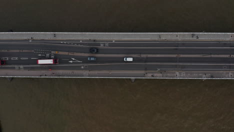 Aerial-birds-eye-overhead-top-down-ascending-view-of-traffic-on-Waterloo-Bridge-over-Thames-river.-Cars-and-buses-driving-on-road.-London,-UK