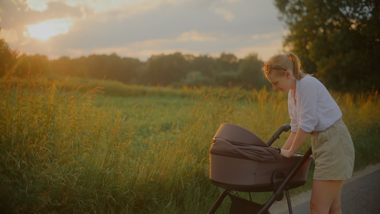 Mother Soothes Child in Stroller at Sunset
