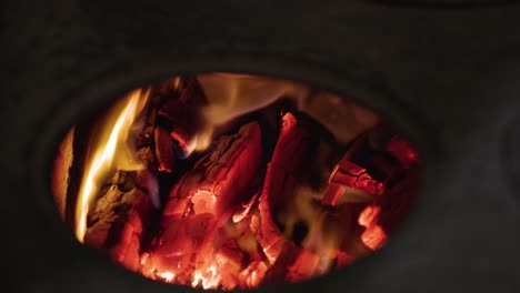 male hand adding wood burning to the stove - static shot