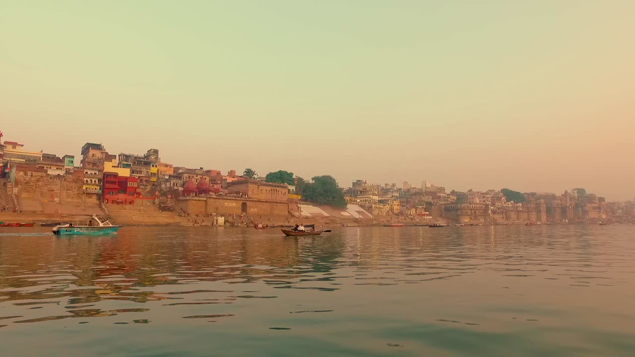 el amanecer de la mañana brilla en los edificios a lo largo del río ganges en varanasi, india