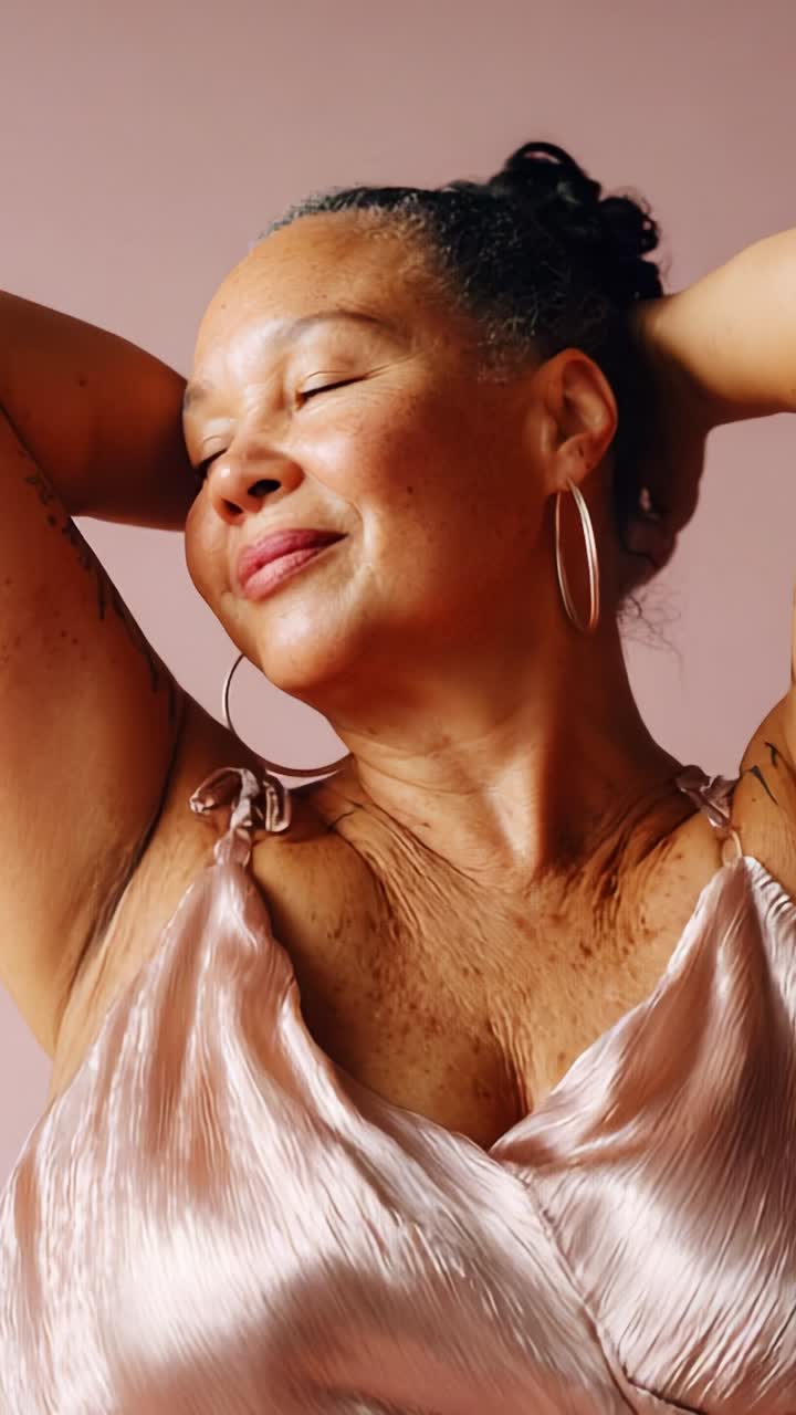 Retrato elegante de uma mulher confiante que exala beleza com uma expressão serena e acessórios estilosos sobre um suave plano de fundo rosa