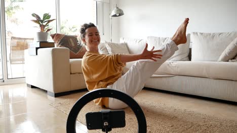 woman practicing yoga at home and watching tutorial on smartphone