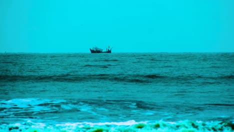 distant view of fishing trawler in bay of bengal with powerful waves on a stormy weather