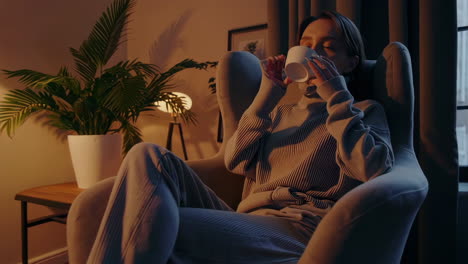woman relaxing with drink in cozy home setting
