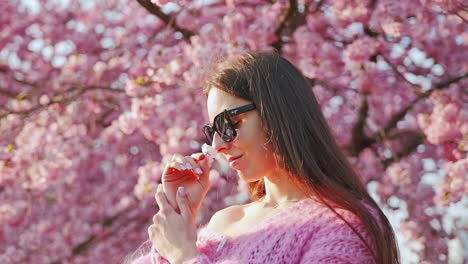 close-up, woman savoring cherry blossom scent under sakura trees in spring light