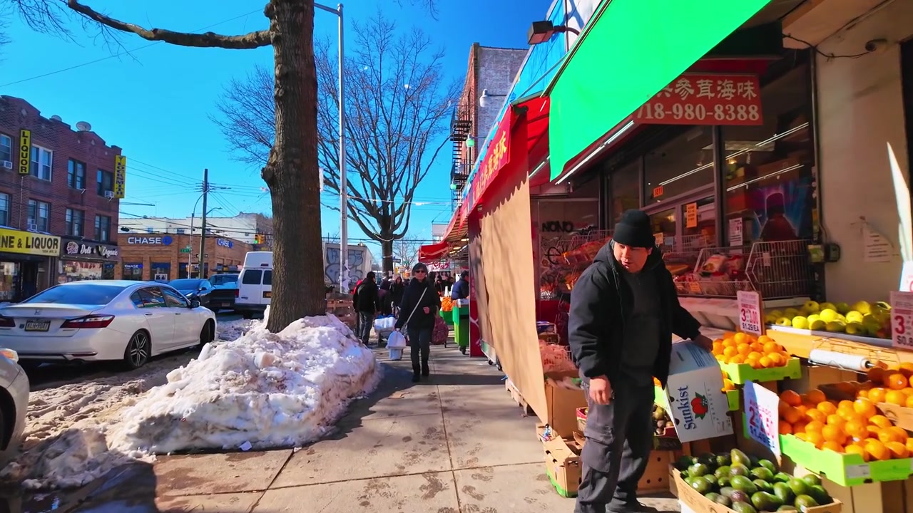 Nueva York, EE. UU., 9 de enero de 2025: Acera nevada con tiendas en Nueva York. Concurrida acera invernal con pequeñas tiendas y peatones en un barrio de Nueva York