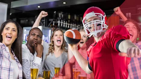 animation of male american football player over happy diverse sport fans watching game at bar