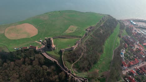 Vista-Aérea-Sobre-El-Hito-De-La-Ladera-Del-Castillo-De-Scarborough-Con-Vistas-Al-Hermoso-Paisaje-Urbano-Del-Puerto-Inglés-Costa