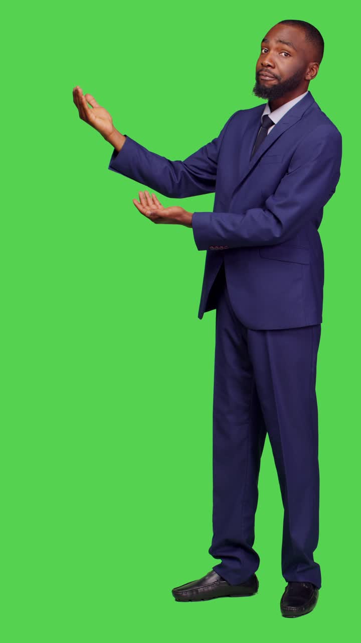Vertical video: Side view of businessman in office suit pointing sideways on camera