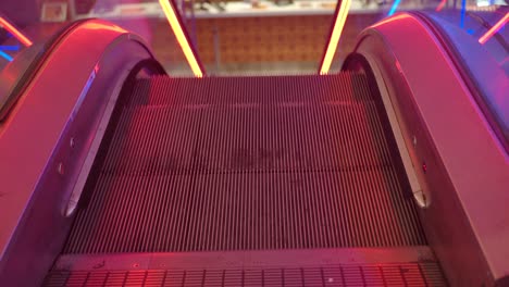 escalator going up with red and blue lights