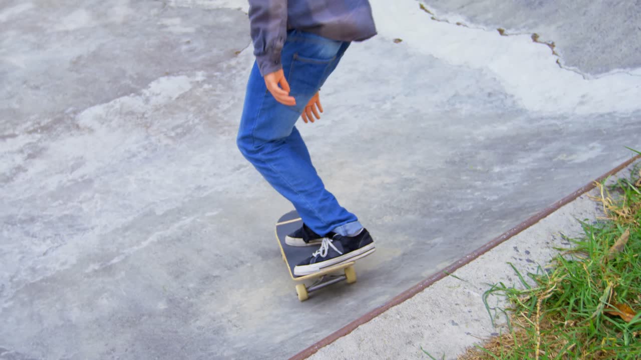 vista trasera de un joven practicando patinaje en la rampa en el parque de patinaje 4k