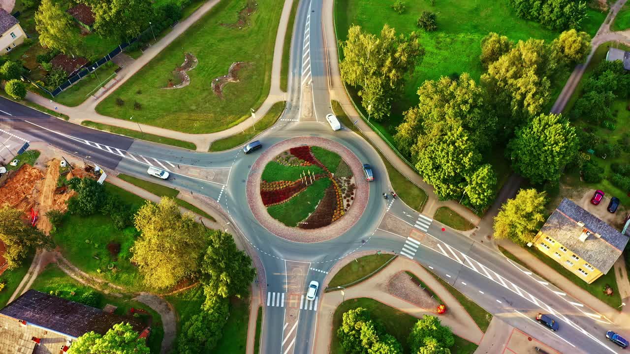 Drone view of a traffic circle with landscaped island, managing urban transportation in Smiltene
