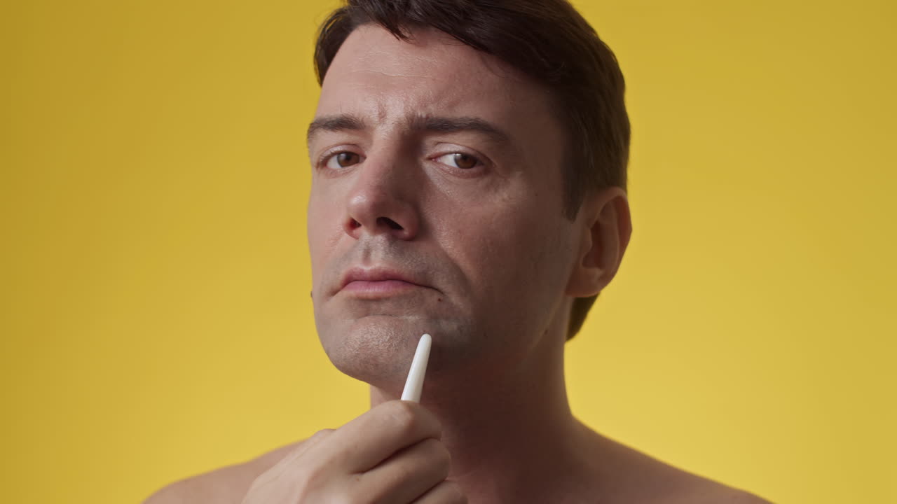 Middle-aged Man Doing Facial Massage with Gua Sha Tool