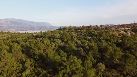 Tilting-drone-shot-revealing-the-ruins-of-Sillyon-and-a-modern-Turkish-town-below,-located-in-Antalya-Province,-in-Turkey