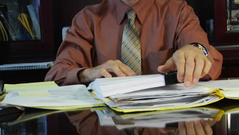 a businessman shuffles through a pile of papers