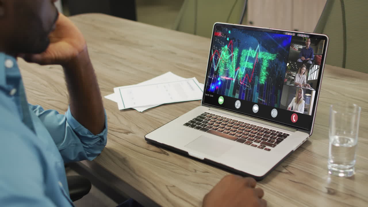 African american businessman using laptop for video call with diverse business colleagues