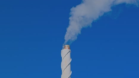 beautiful view of smoke coming out of chimney against blue sky. ecology and greenhouse effect concept. sweden.