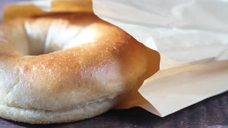 fresh bagel bread in a paper on table