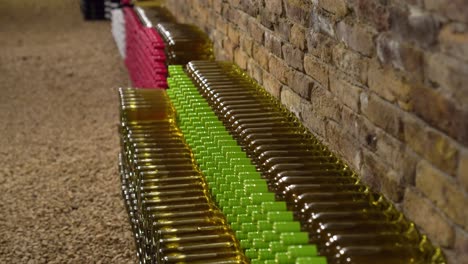 Collection-of-white-wine-bottles-displayed-in-bricked-underground-cellar-closeup