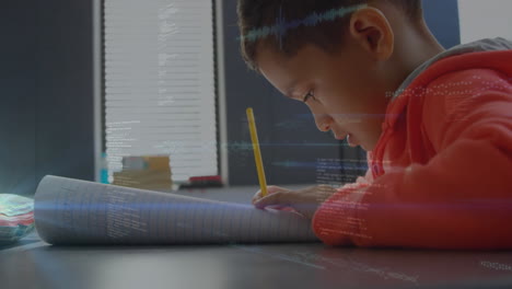 student writing in home study area with notebook and pencil, showcasing digital education charts