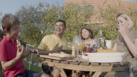 familia feliz almorzando en el jardín de su casa