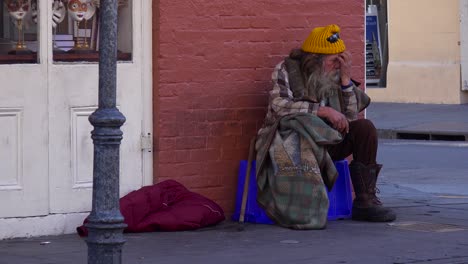 a homeless man sits on the street