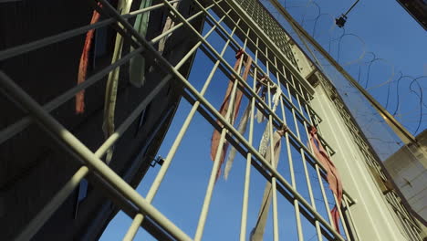 Metal-prison-fence-with-prisoners'-bracelets-containing-messages-of-freedom