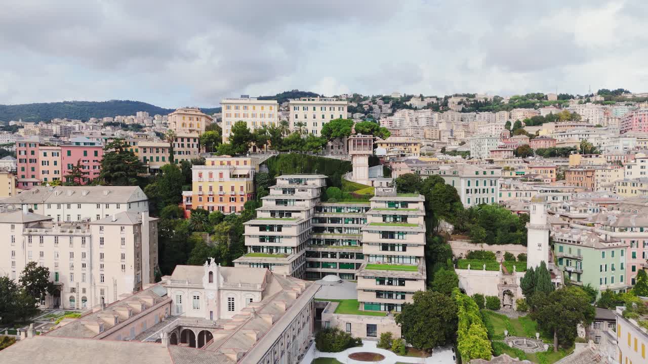 Genoa's historic center with colorful hillside buildings and lush greenery, aerial view