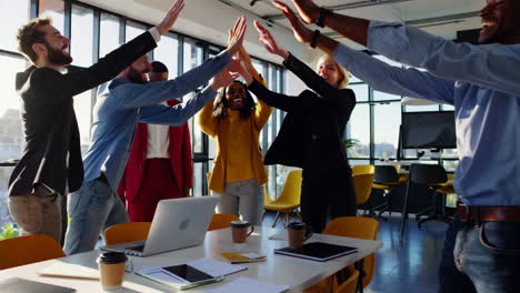 Diverse Business Team Celebrates Success with High-Fives in a Modern Office