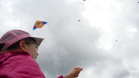 child flying kites on a cloudy day