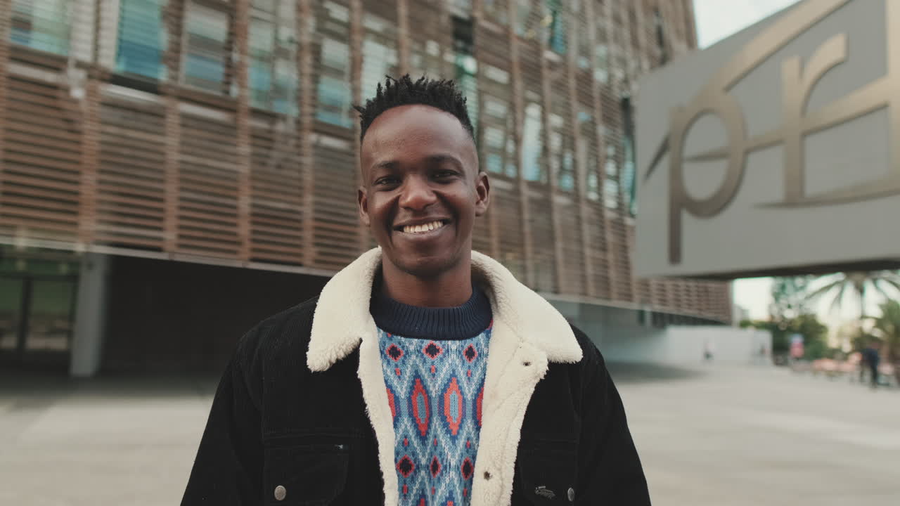 Uomo africano sorridente di fronte a un edificio